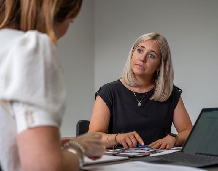 2 ladies in office talking to each other